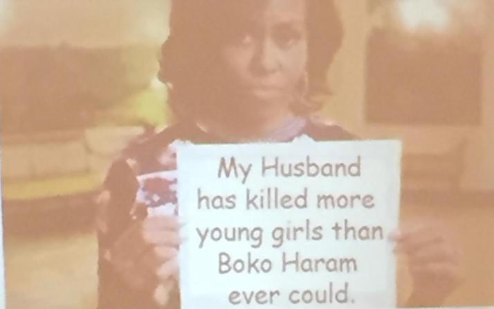 Michelle Obama holding a sign saying My husband has killed more young girls than Boko Haram ever could
