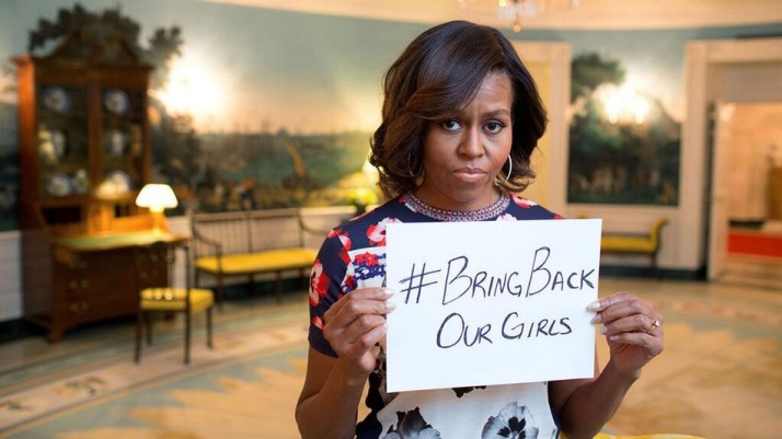 Michelle Obama holding a sign that says #BringBackOurGirls